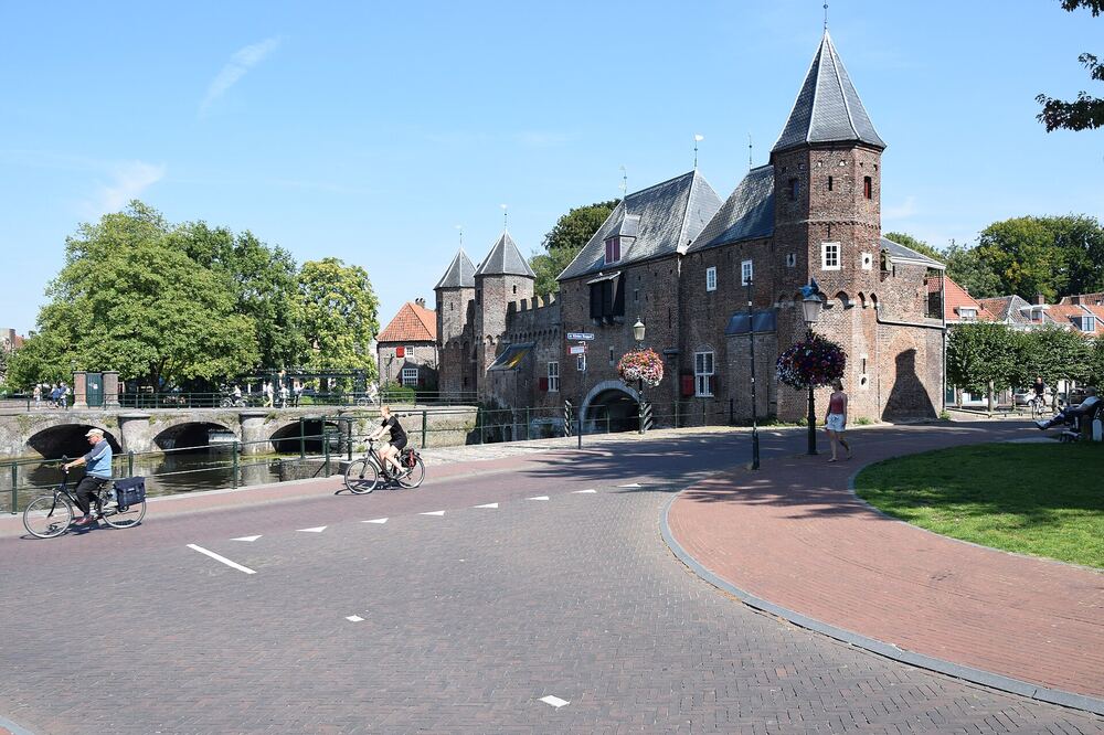 De Koppelpoort in Amersfoort gezien vanaf de brug, met fietsers op de kade